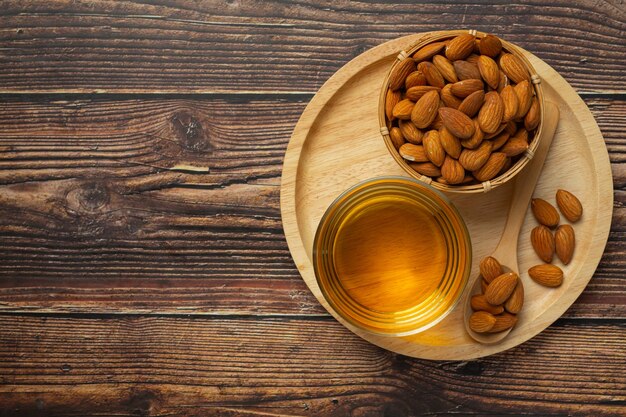 Almond oil in bottle on dark wood background