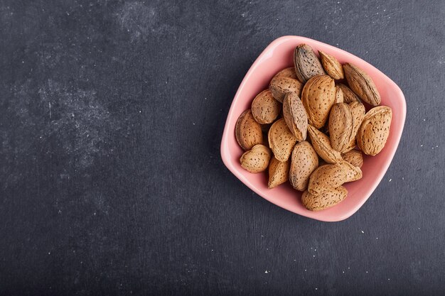 Almond shells in a pink saucer, top view. 