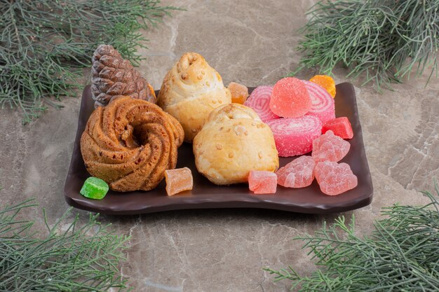 Almond wraps and marmelade on a next to pine leaves on marble. 