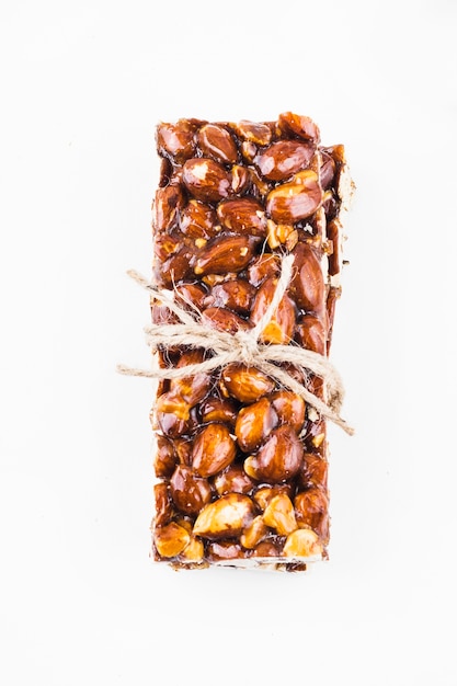 Almonds bar tied with string on white background