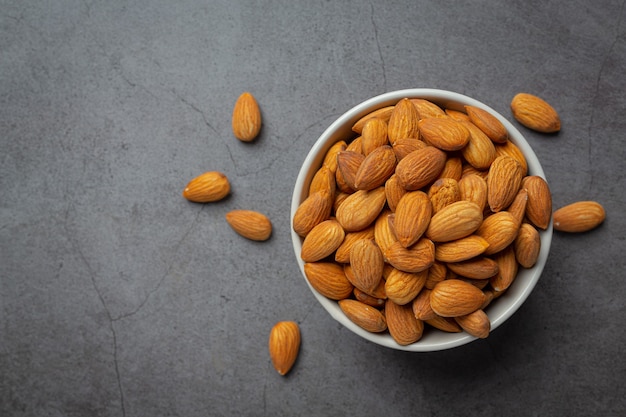 Almonds in bowl on dark background