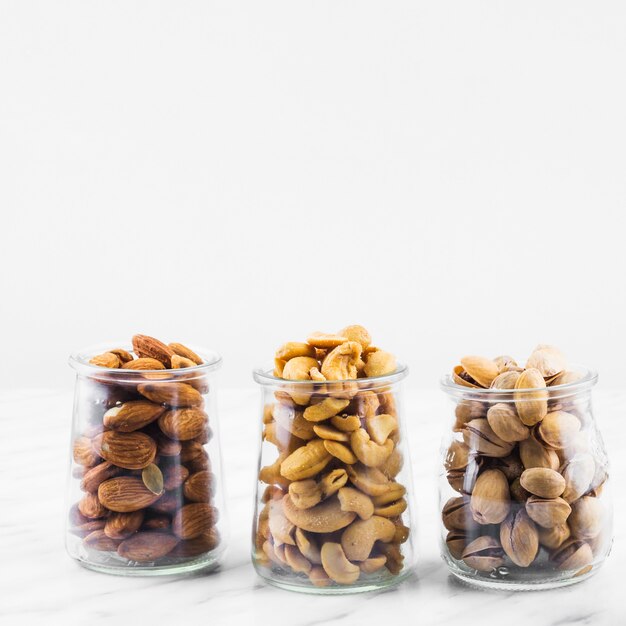 Миндаль; cashewnuts и фисташки на мраморном фоне