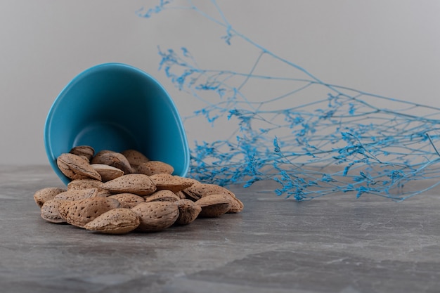 Free photo almonds in overturned bowl on the marble surface