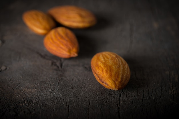 Almonds on wooden background.