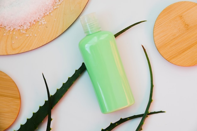 aloe vera leaves with a beauty cream bottle