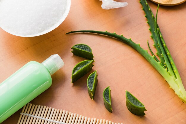 aloe vera leaves with a beauty cream bottle