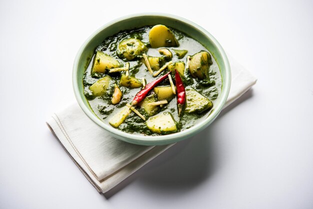 Алоо палак сабзи или карри со шпинатом и картофелем, подаваемое в миске. популярный индийский рецепт здорового питания. выборочный фокус
