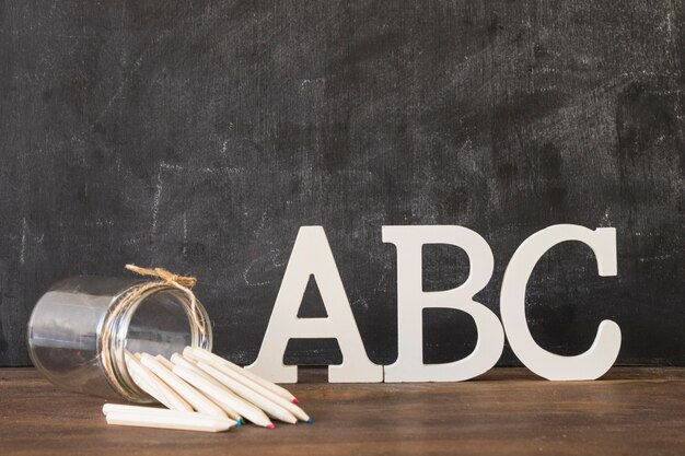 Alphabet letters with pens on table 