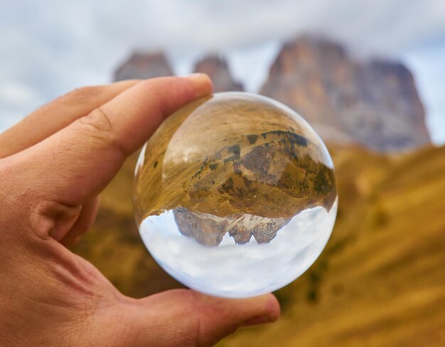 Alpine mountain view through crystal glass globe Dolomites Alps