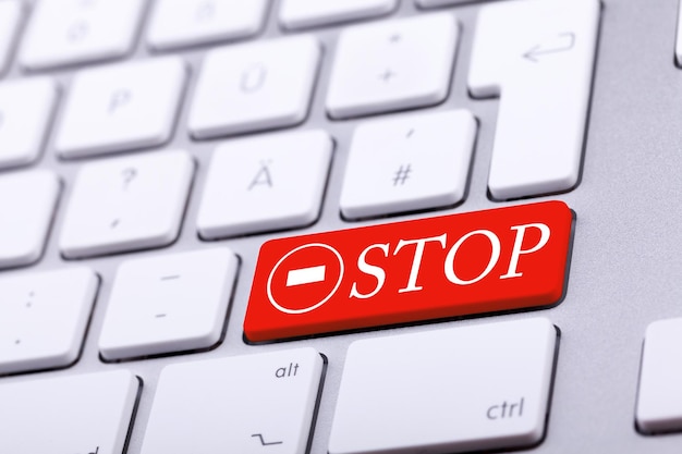 Aluminium keyboard with STOP word and sign in red. Studio photo. Standard keyboard in close up shooting with blurred background. Alert