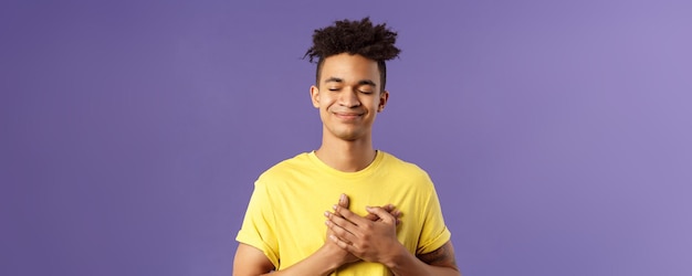 Always in my heart touched carefree handsome young man with dreads yellow tshirt close eyes and smil