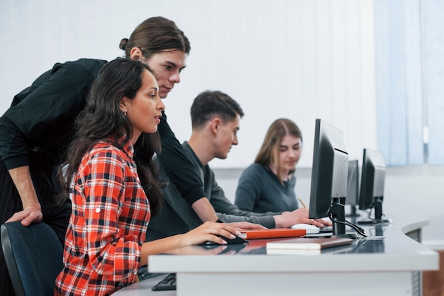 Foto gratuita lo sto facendo bene. gruppo di giovani in abiti casual che lavorano nell'ufficio moderno