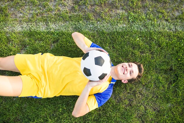 Amateur football concept with lying man throwing ball