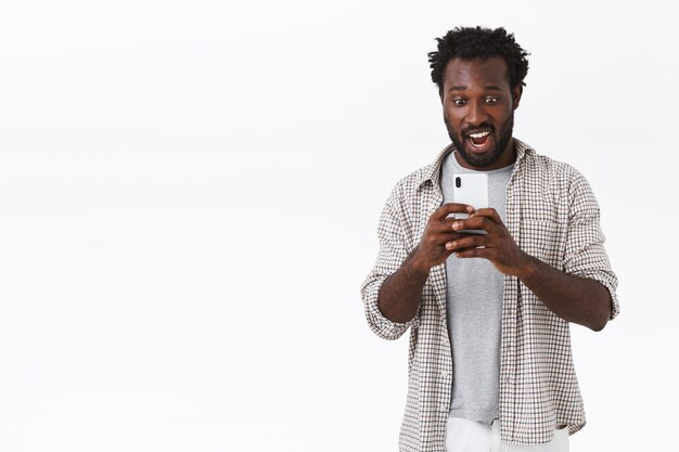 Amazed and astonished african-american bearded guy recording some awesome video