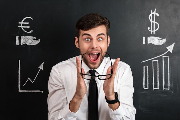 Free photo amazed bearded businessman takes off his glasses