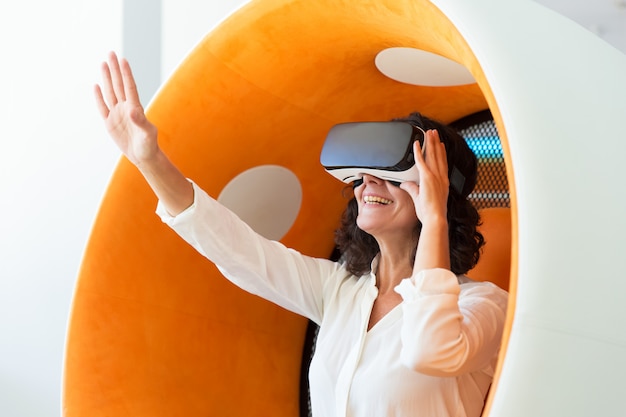 Amazed business woman in VR headset touching air