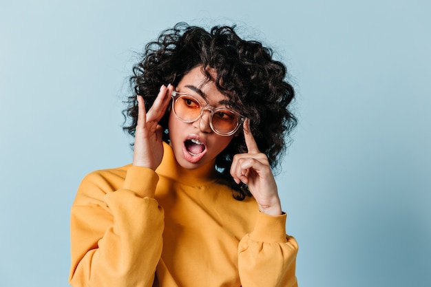 Amazed curly woman posing in sunglasses – Free Stock Photo