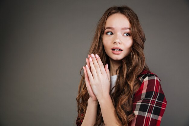 Amazed cute young woman with opened mouth looking away