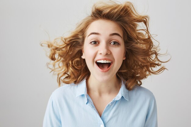 Amazed happy girl with curly hair floating in air