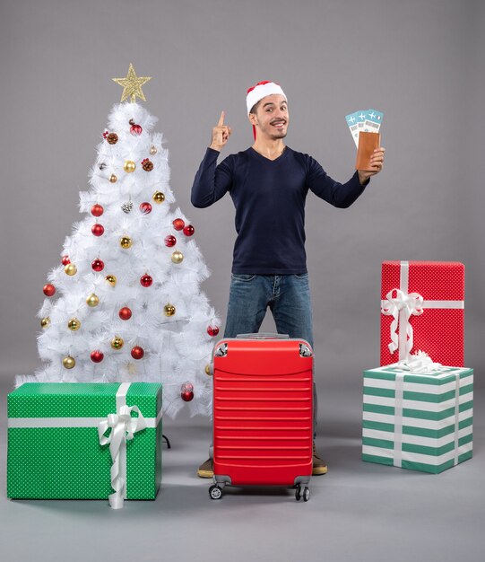 amazed man holding his travel tickets and pointed something on grey