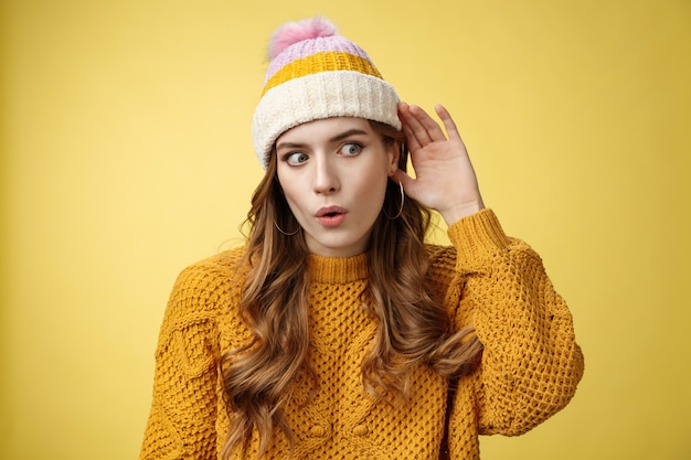 Foto gratuita stupita scioccata attraente curiosa giovane donna che origlia una conversazione interessante piega le labbra wow suono stupito scopri i segreti dell'amico in piedi dietro la porta tieni la mano vicino all'orecchio ascolta la voce