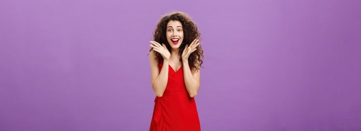 Free Photo amazed and surprised attractive charming adult woman with curly hairstyle in red elegant dress raisi