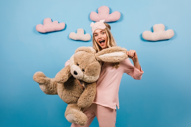 Amazed woman holding big toy rabbit