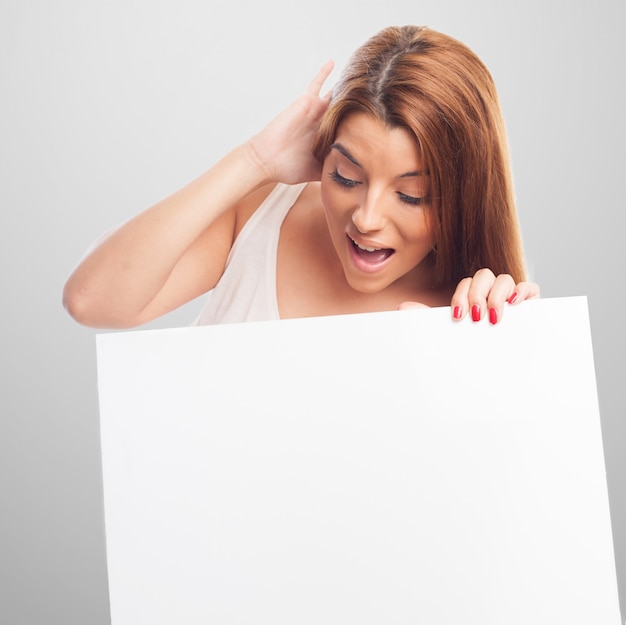 Free photo amazed woman looking at billboard