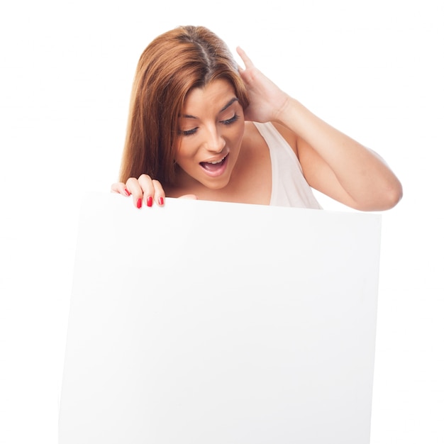 Amazed woman looking down at billboard