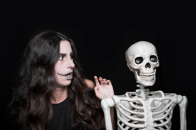 Free photo amazed woman looking at skeleton