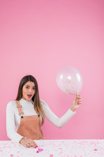 Amazed woman standing with air balloon 