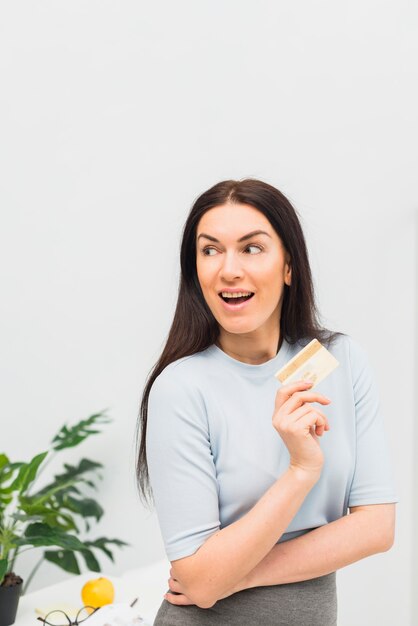 Amazed woman standing with credit card