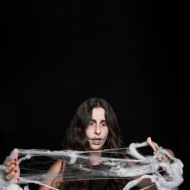 Free photo amazed woman tangling in fake cobweb