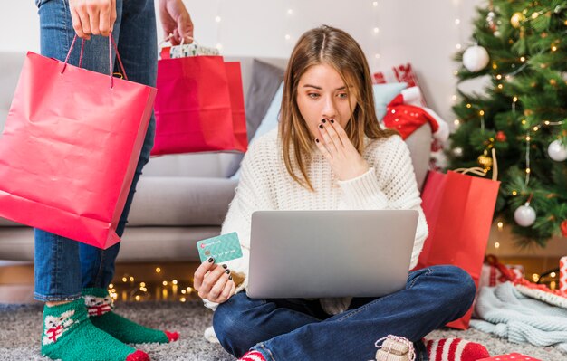 Amazed woman with card sitting at man 