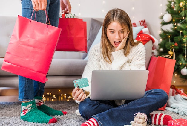 Amazed woman with credit card and legs of man 