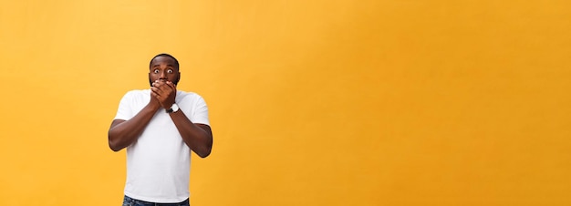 Foto gratuita stupito giovane hipster afroamericano che indossa una maglietta bianca tenendosi per mano in un gesto sorpreso keepin