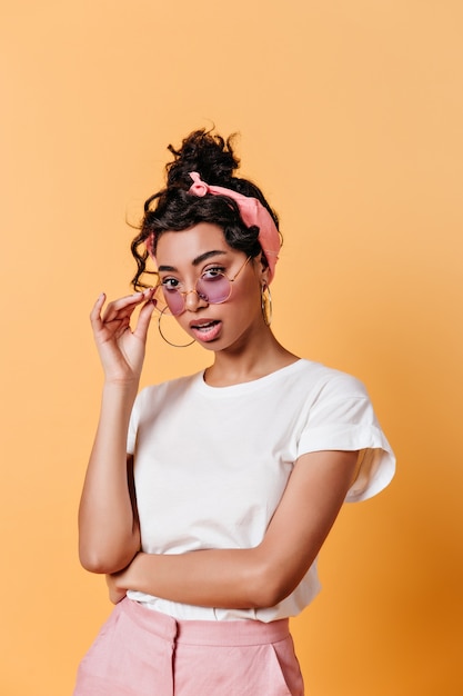 Amazed young woman touching sunglasses