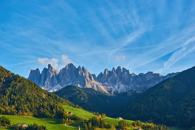 Free photo amazing autumn scenery in santa maddalena village with church colorful trees and meadows under rising sun rays dolomite alps italy