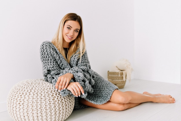 Free photo amazing beautiful woman in trendy sweater lying on the floor and smiling
