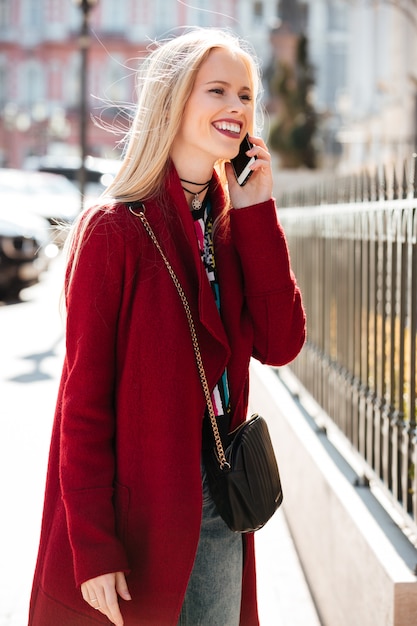 Удивительная мода молодая блондинка разговаривает по телефону.