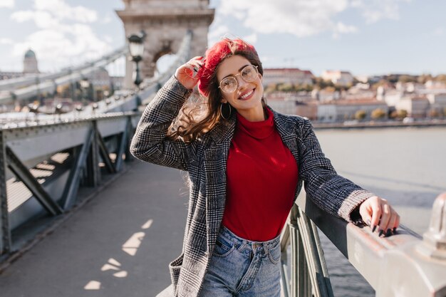 Amazing french woman posing with hair waving, relaxing during walk down the bridge