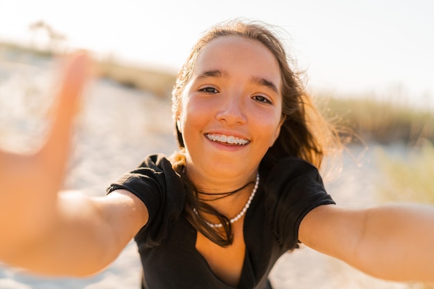 Удивительная девушка развлекается и делает автопортрет на камеру на солнечном пляже
