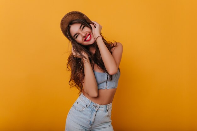 Amazing girl with bright makeup posing with happy smile on yellow space