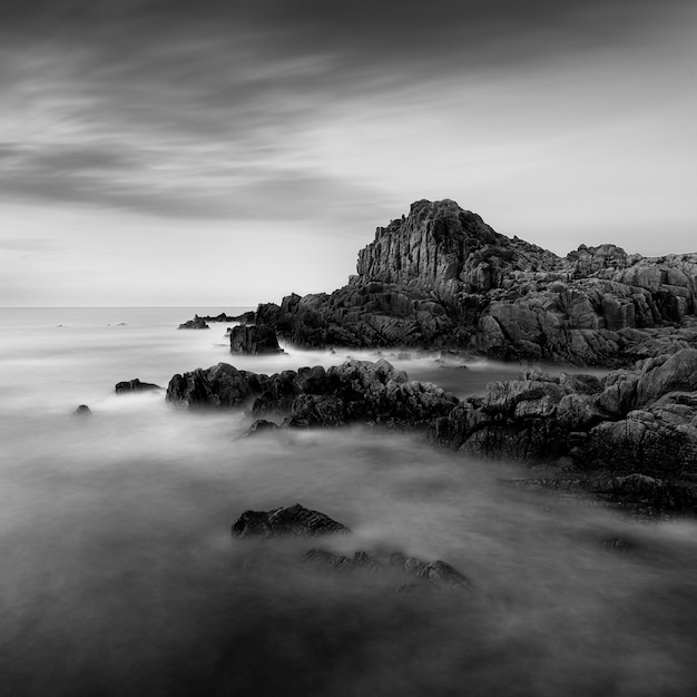 Amazing grayscale shot of a rocky beach in Guernsey near the Fort Houmet