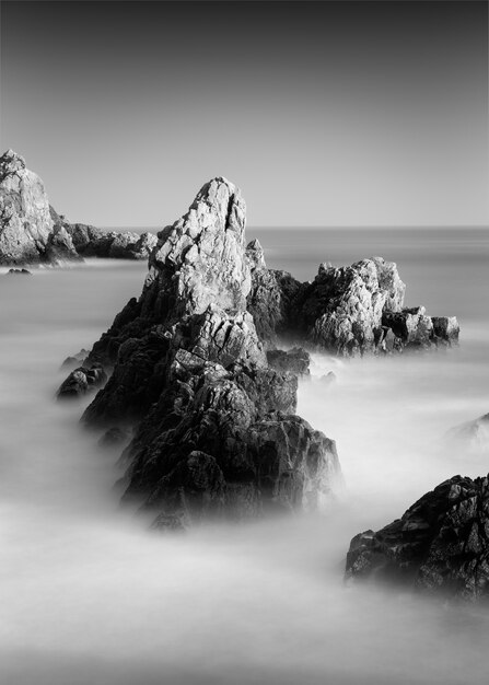 Amazing grayscale shot of a rocky beach in Guernsey