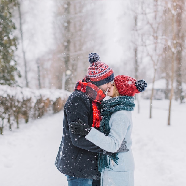 Amazing kissing couple in snow falling