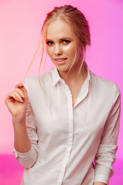 Amazing lady standing and posing over pink wall.