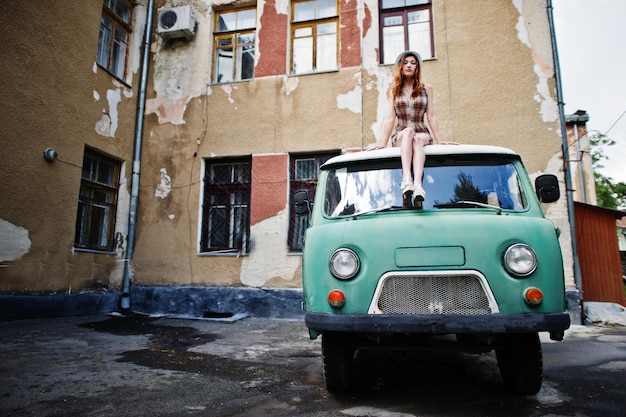 Free photo amazing long legs with hig heels girl wear on hat sitting on roof of old retro minivan