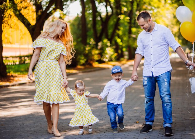 Amazing parents have fun with their two children walking in the park 