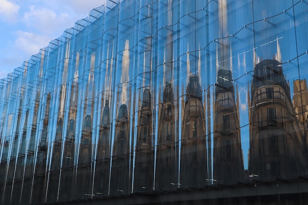 Amazing reflection of a traditional classic building in a modern glassfacade on the street of paris